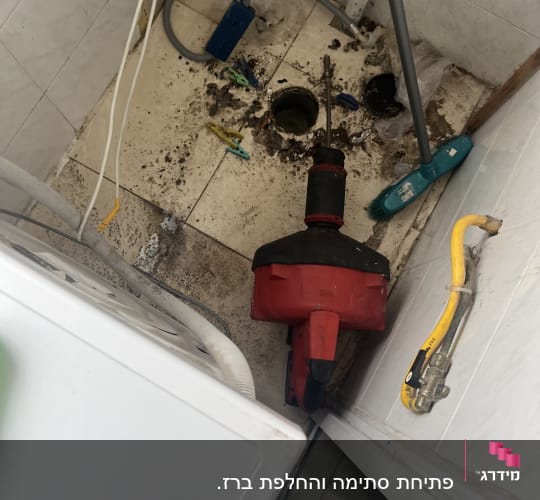 כלי עבודה של אינסטלטור ליד חור ברצפה